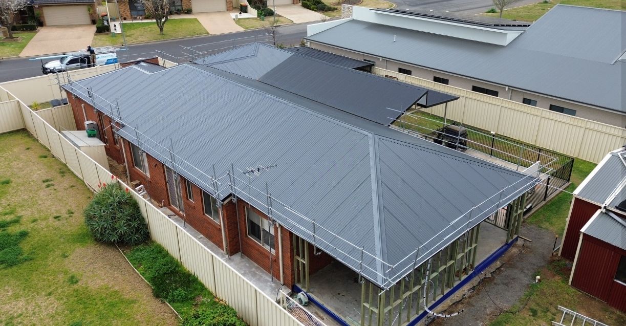 A Residential House With Scaffolding Around New Roof — Essential Roofing and Plumbing in Harden, NSW