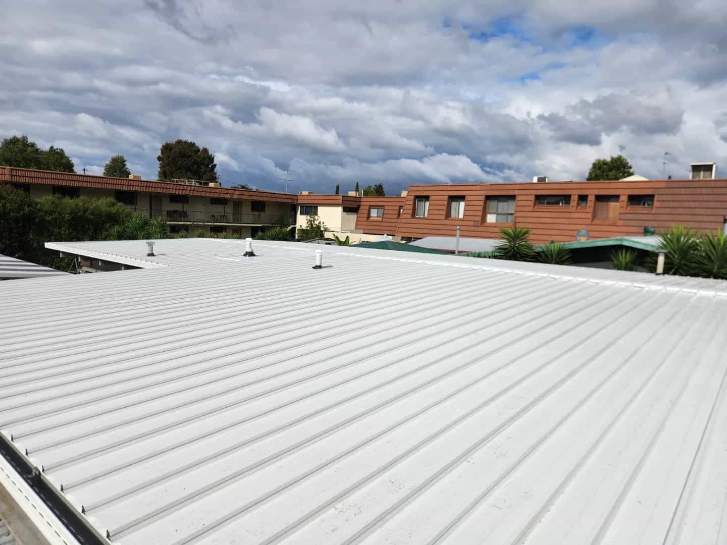 A White Roof With a Cloudy Sky in the Background — Essential Roofing and Plumbing in Gundagai, NSW