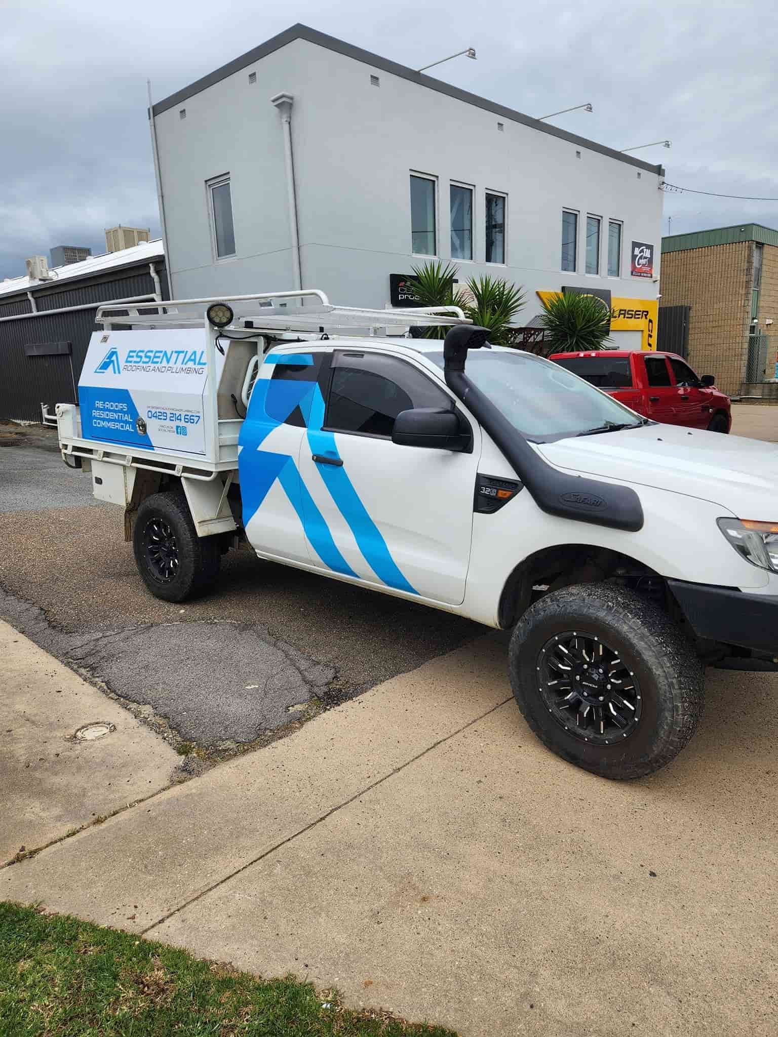 A White Truck With Blue Stripes on the Side Parked in Front of a Building — Essential Roofing and Plumbing in Gundagai, NSW