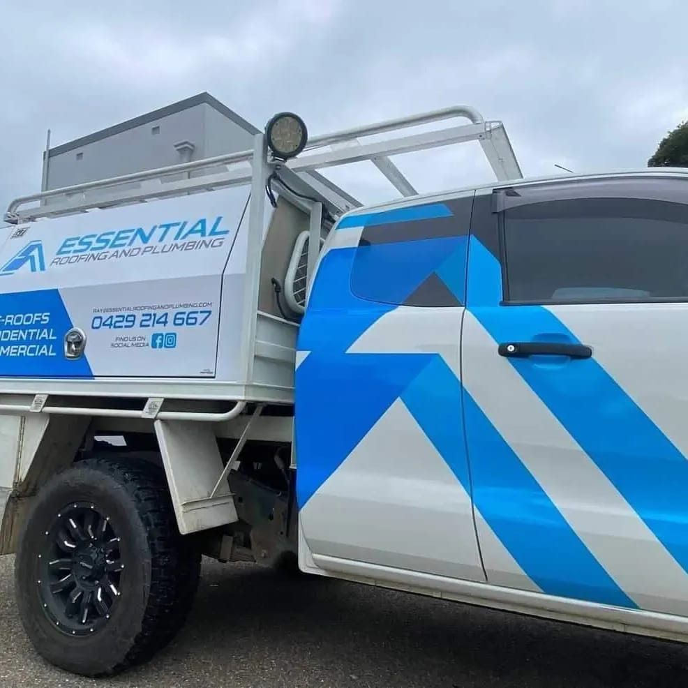 A White Truck With Blue Stripes on the Side is Parked — Essential Roofing and Plumbing in Harden, NSW