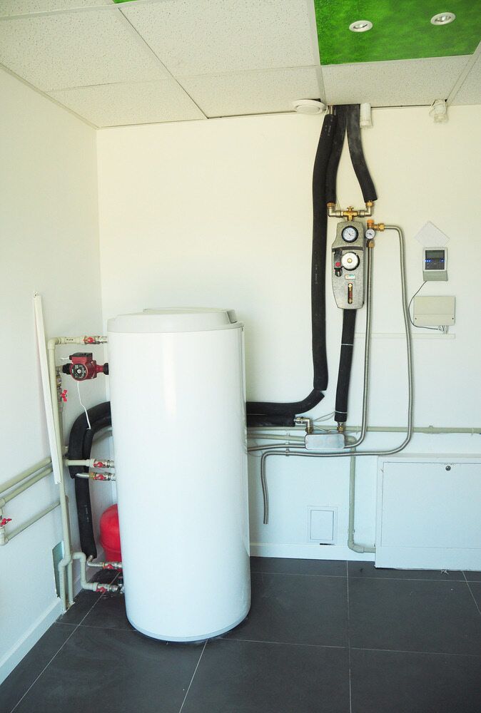 A White Water Heater is Sitting in the Middle of a Room — Essential Roofing and Plumbing in Wagga Wagga, NSW