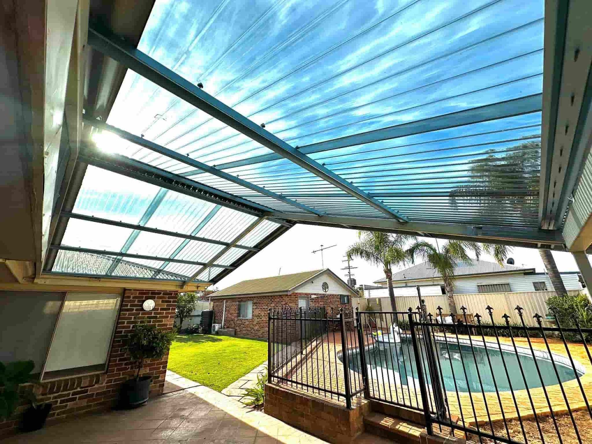 A Clear Roof Over A Patio and pool beside — Essential Roofing and Plumbing in Gundagai, NSW