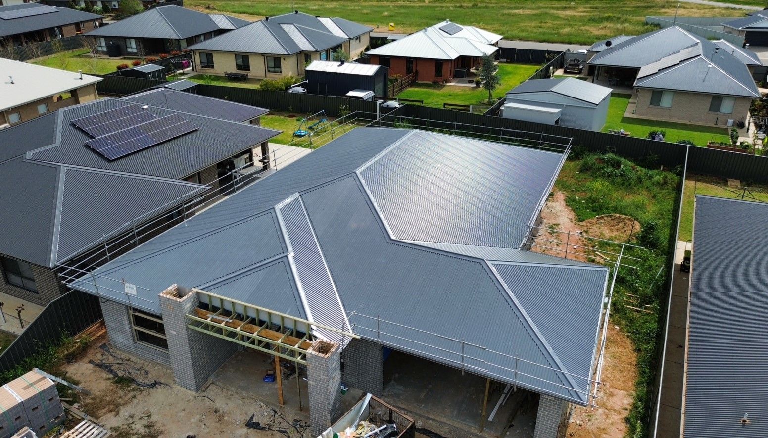 A Roof With a Metal Roof and Scaffolding on It — Essential Roofing and Plumbing in Harden, NSW