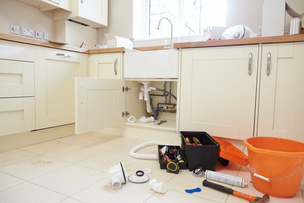 A Kitchen With a Sink Underneath It and Tools on the Floor — Essential Roofing and Plumbing in Wagga Wagga, NSW