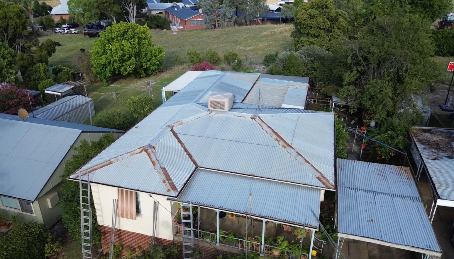 Area shot of a house with a Rusty Metal Roof — Essential Roofing and Plumbing in Wagga Wagga, NSW