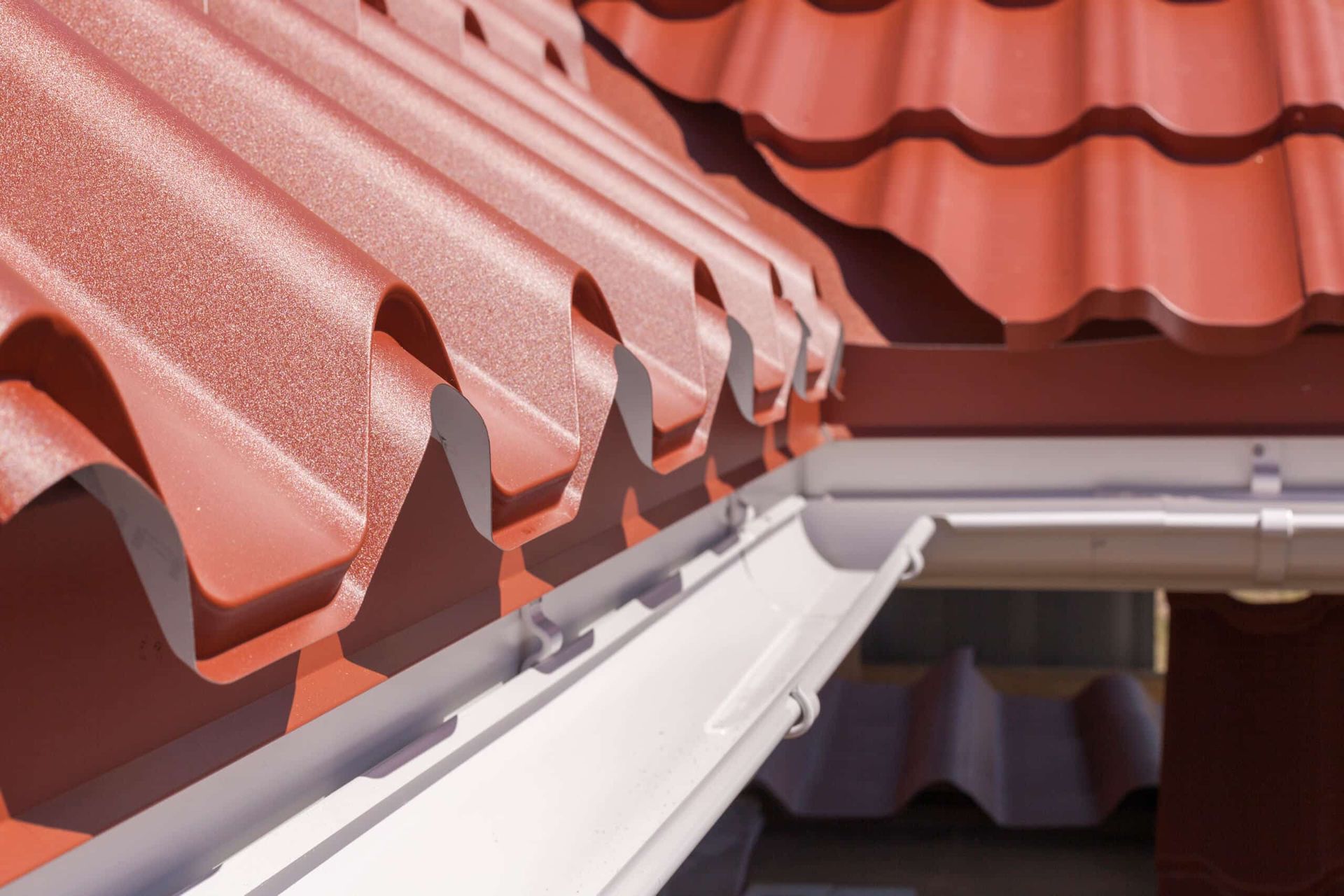 A Close Up of a Gutter on a Red Roof — Essential Roofing and Plumbing in Temora, NSW