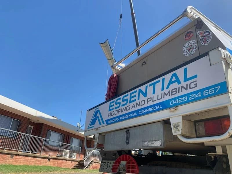 An Essential Roofing and Plumbing Truck is Parked in Front of a Building — Essential Roofing and Plumbing in Young, NSW
