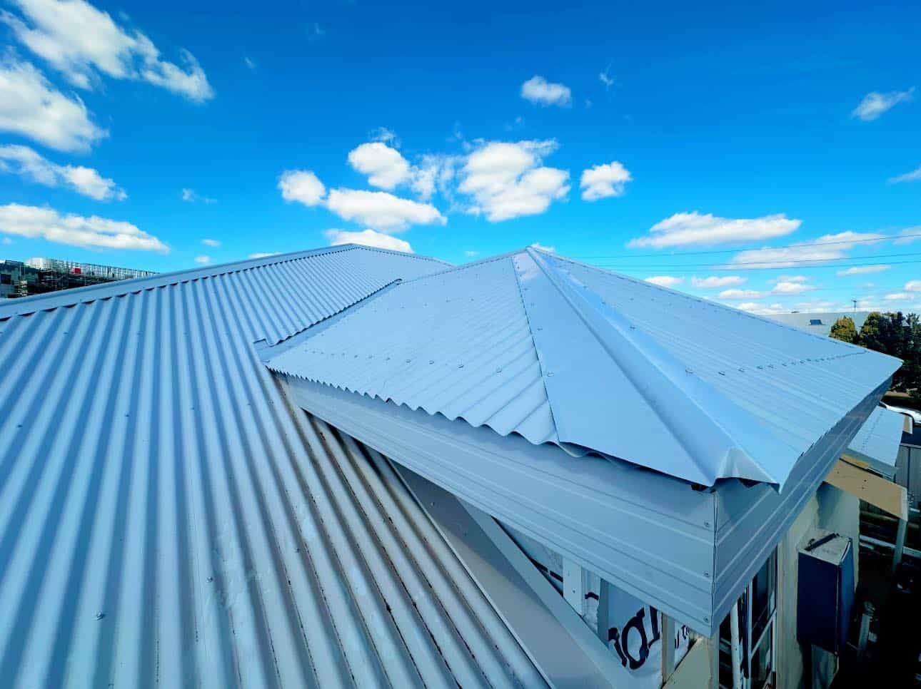 A White Roof With a Blue Sky in the Background — Essential Roofing and Plumbing in Young, NSW
