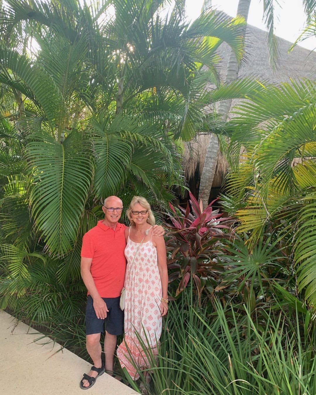 A man and a woman are standing next to each other in a garden.