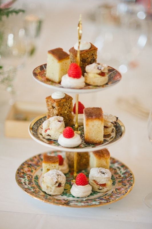 A tiered tray filled with a variety of desserts on a table.