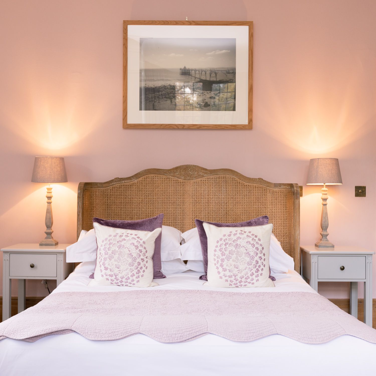 A bedroom with a picture on the wall above the bed