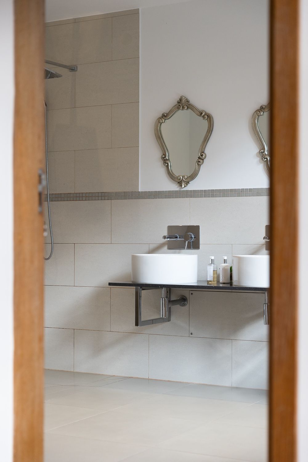 A bathroom with two sinks and two mirrors on the wall