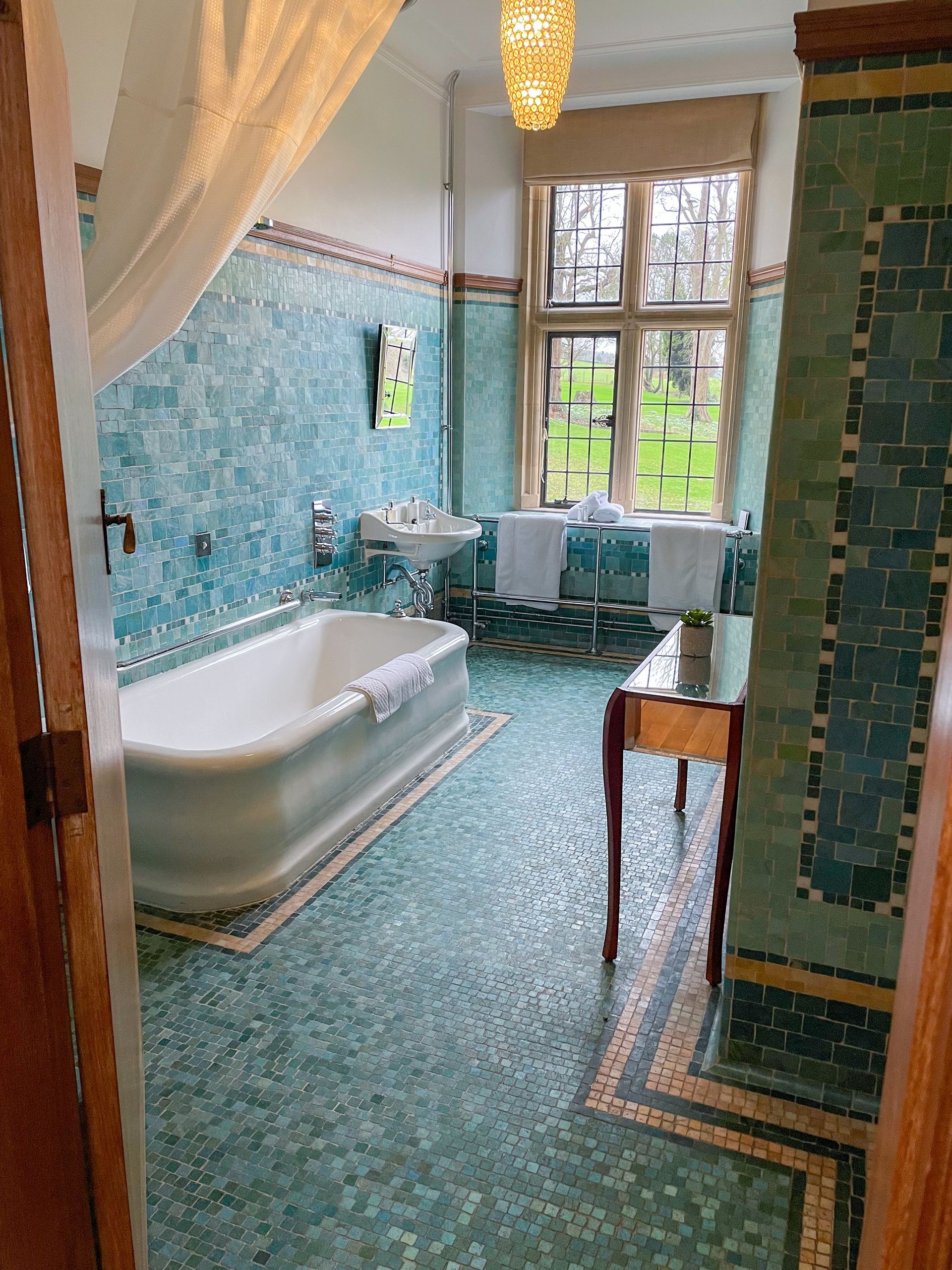 A bathroom with a bathtub , sink , and window.