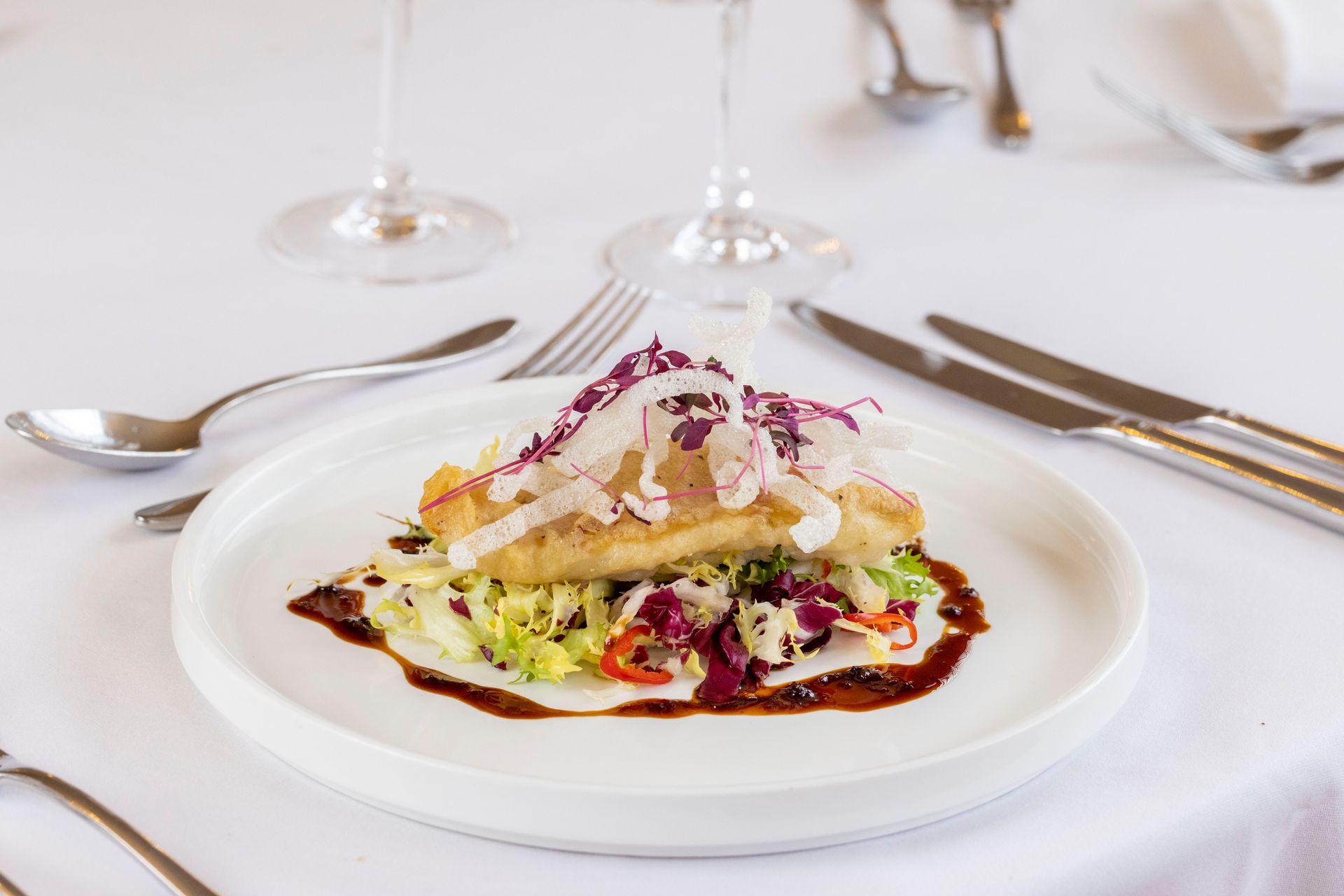 A white plate topped with a piece of food on a table.
