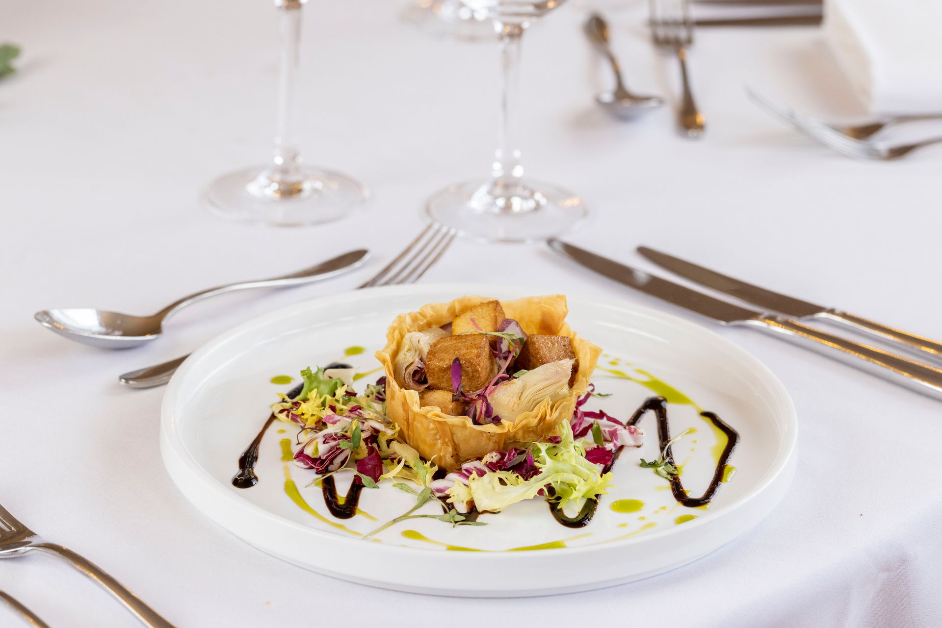 A plate of food is sitting on a table with silverware.