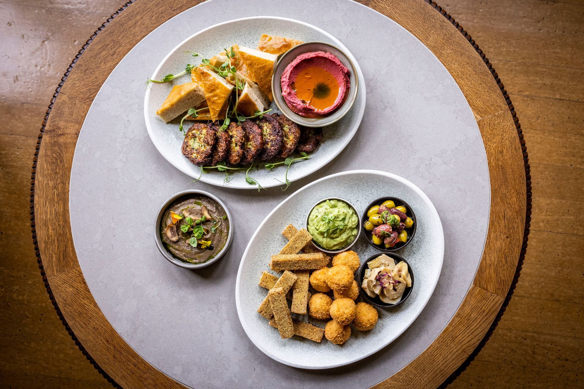 Two plates of food are sitting on a wooden table.