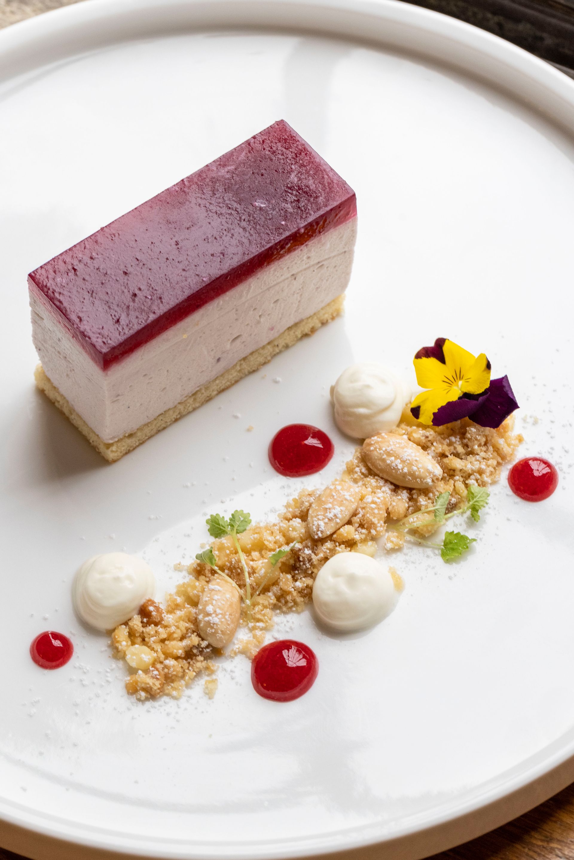 A white plate topped with a piece of cake and nuts.