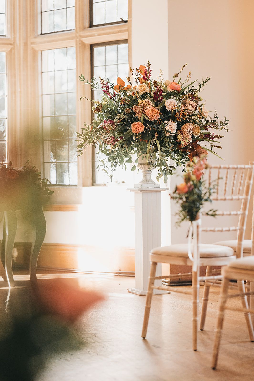 A row of chairs with a vase of flowers in the middle of the room.