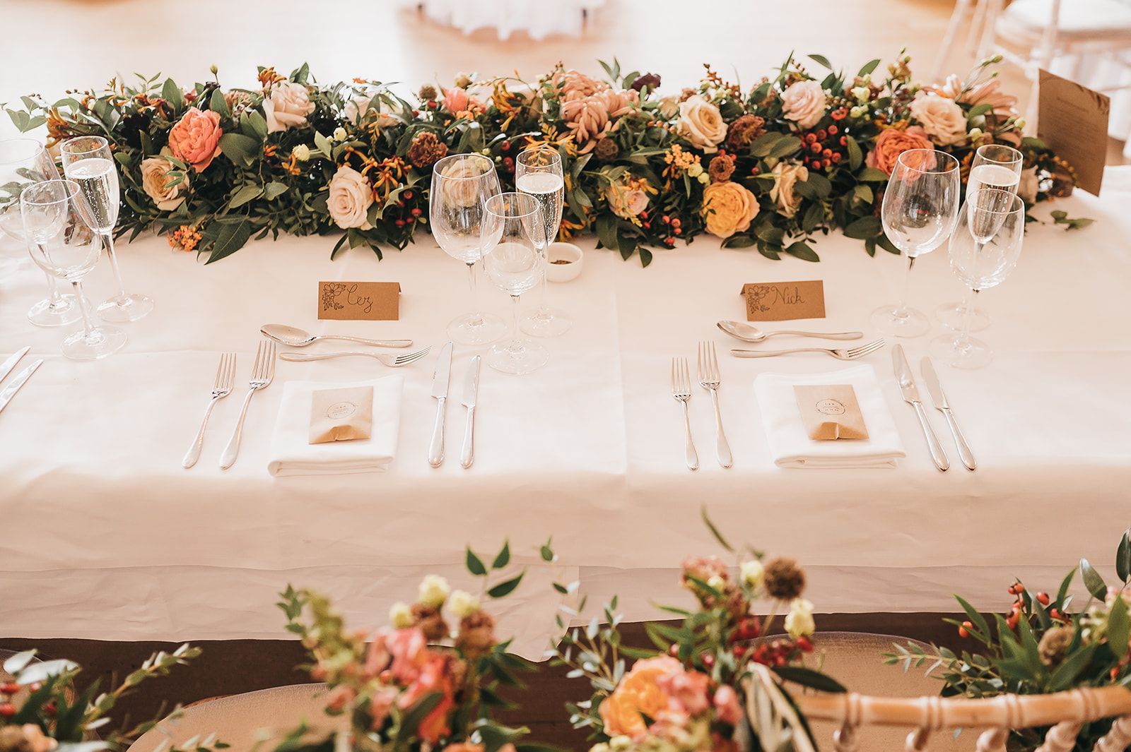 A table with plates , utensils , and flowers on it.