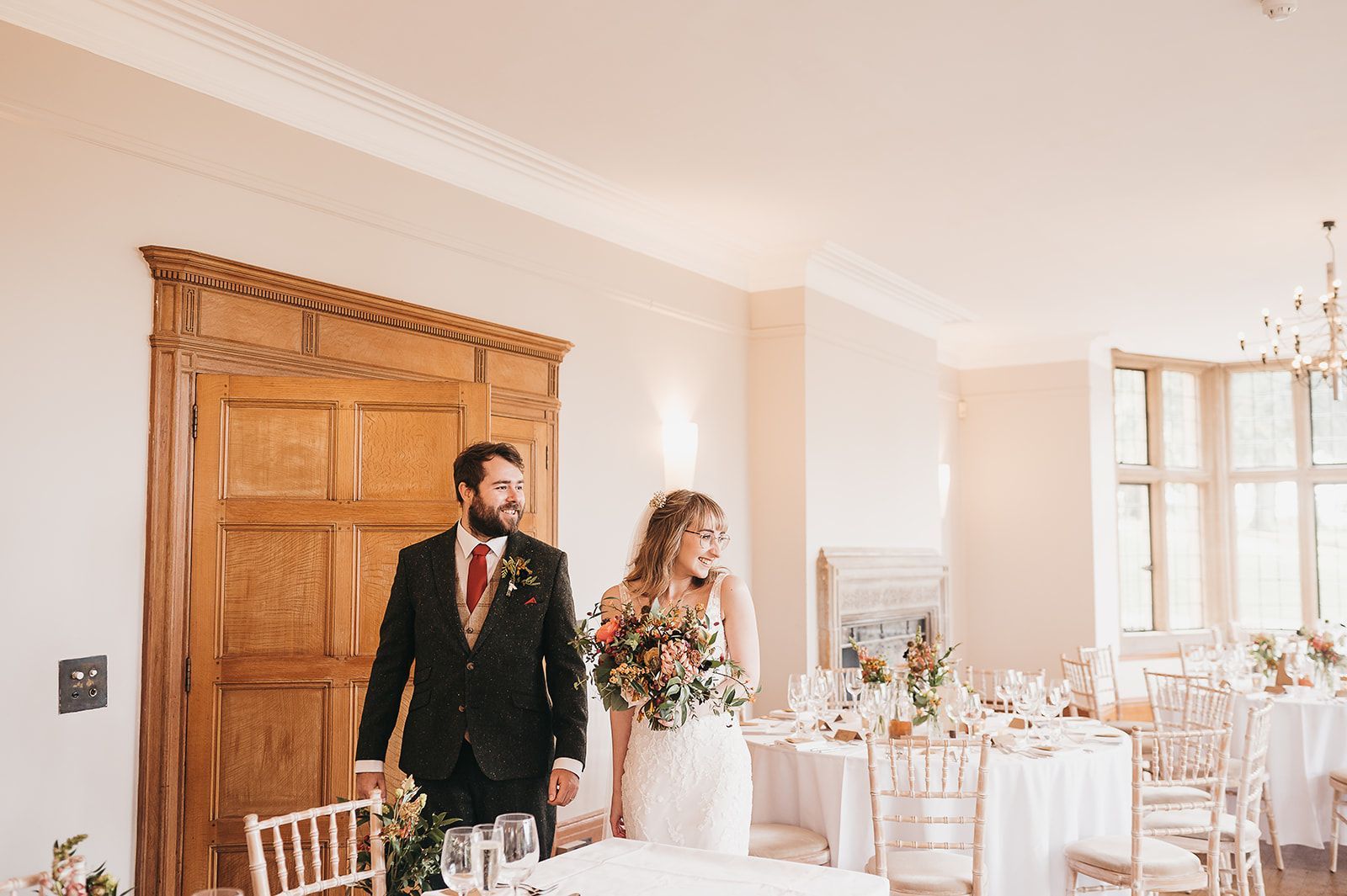 A bride and groom are standing next to a table in a room.