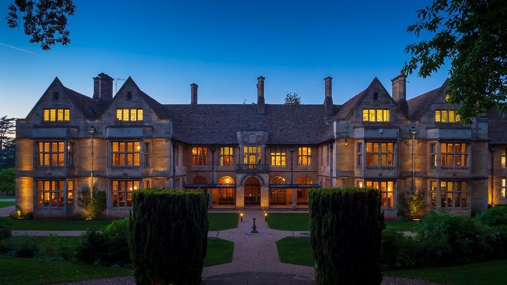 A large brick building with lots of windows is lit up at night.