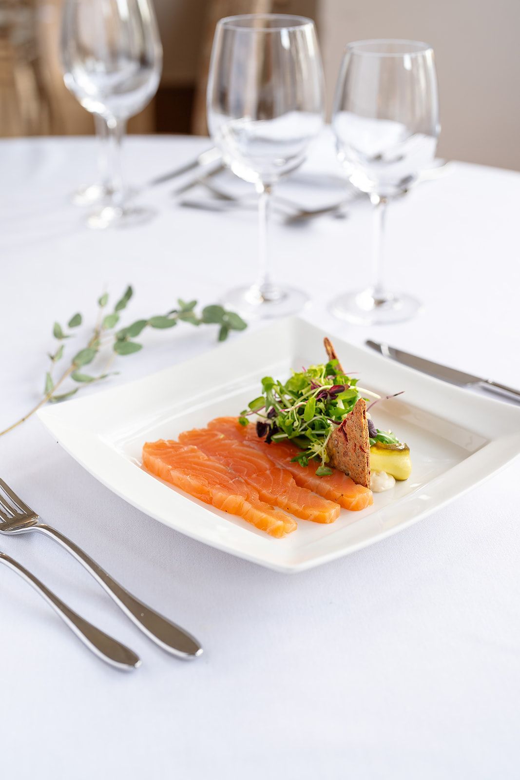 A white plate topped with sliced salmon and asparagus on a table.