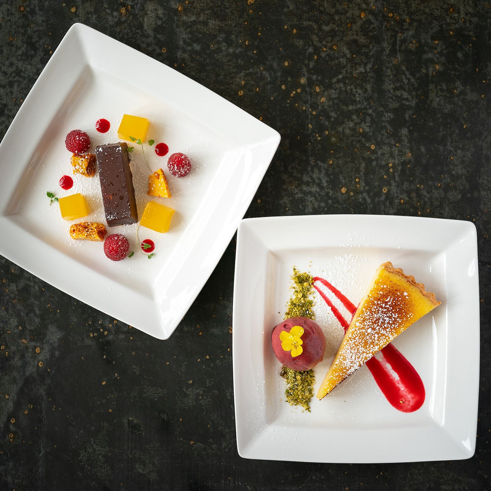 Two square plates with desserts on them on a table