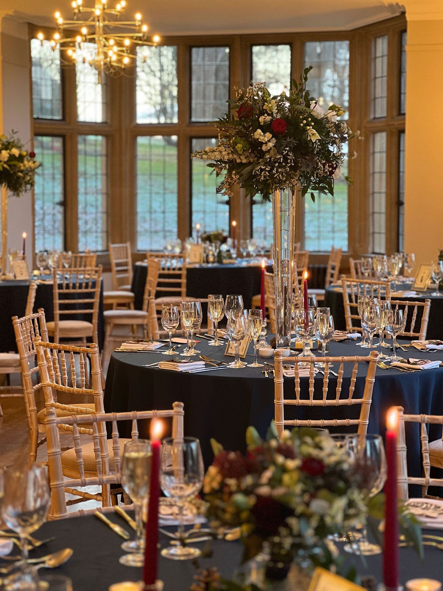 A large room filled with tables and chairs set for a wedding reception.