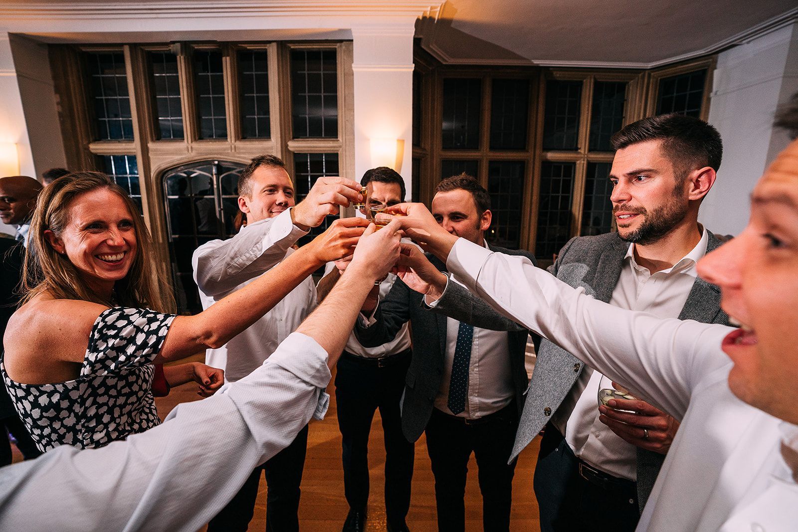 A group of people are toasting with their hands in a room.