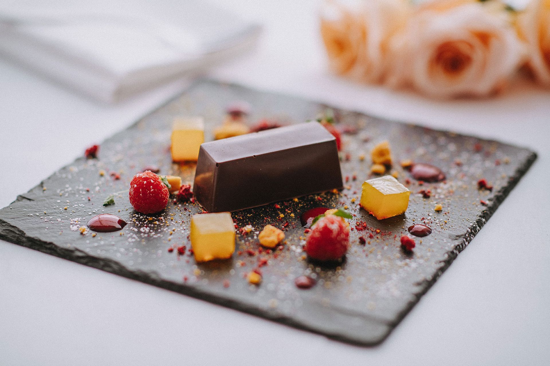 A close up of a dessert on a slate plate on a table.