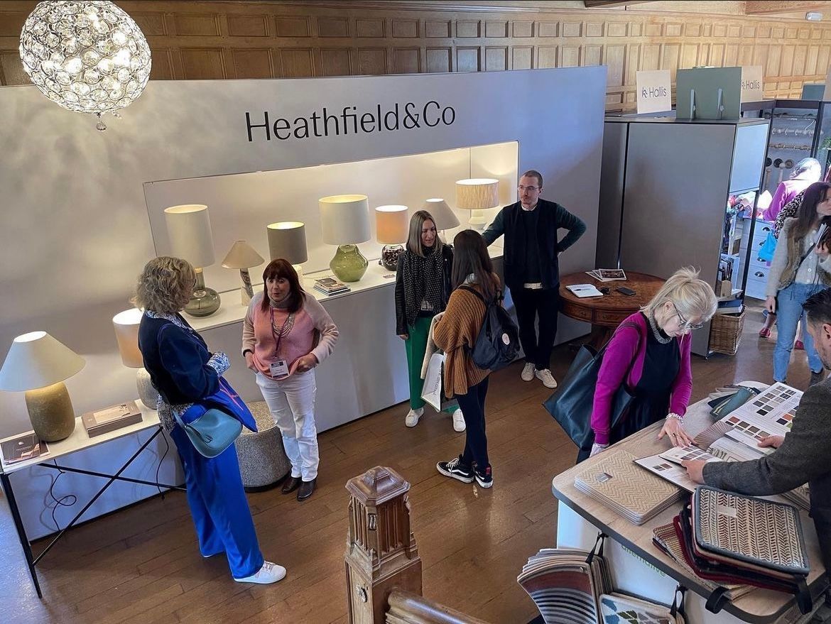 A group of people are standing in a room looking at lamps.