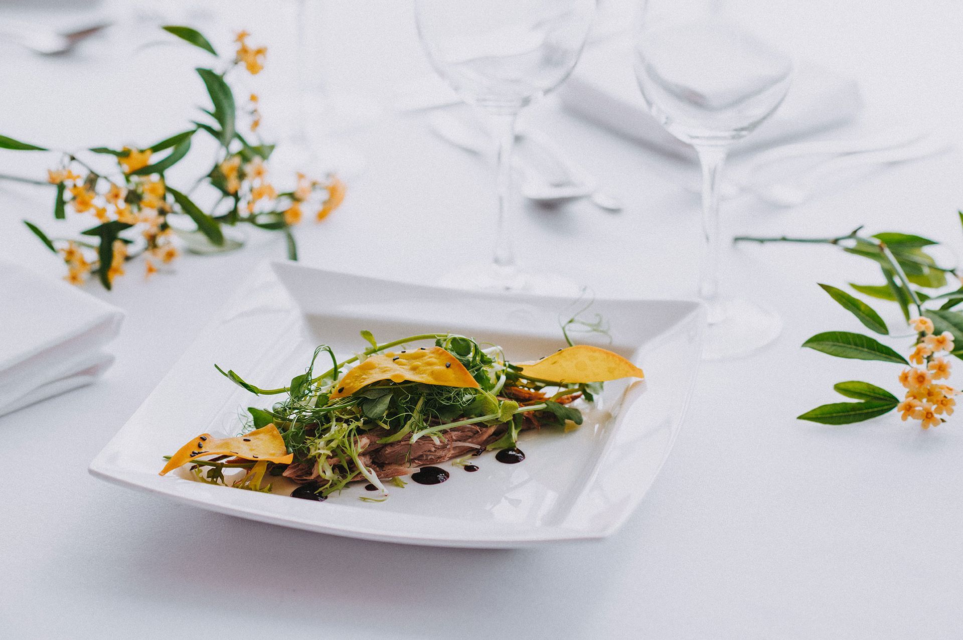 A white plate topped with a salad on a table.
