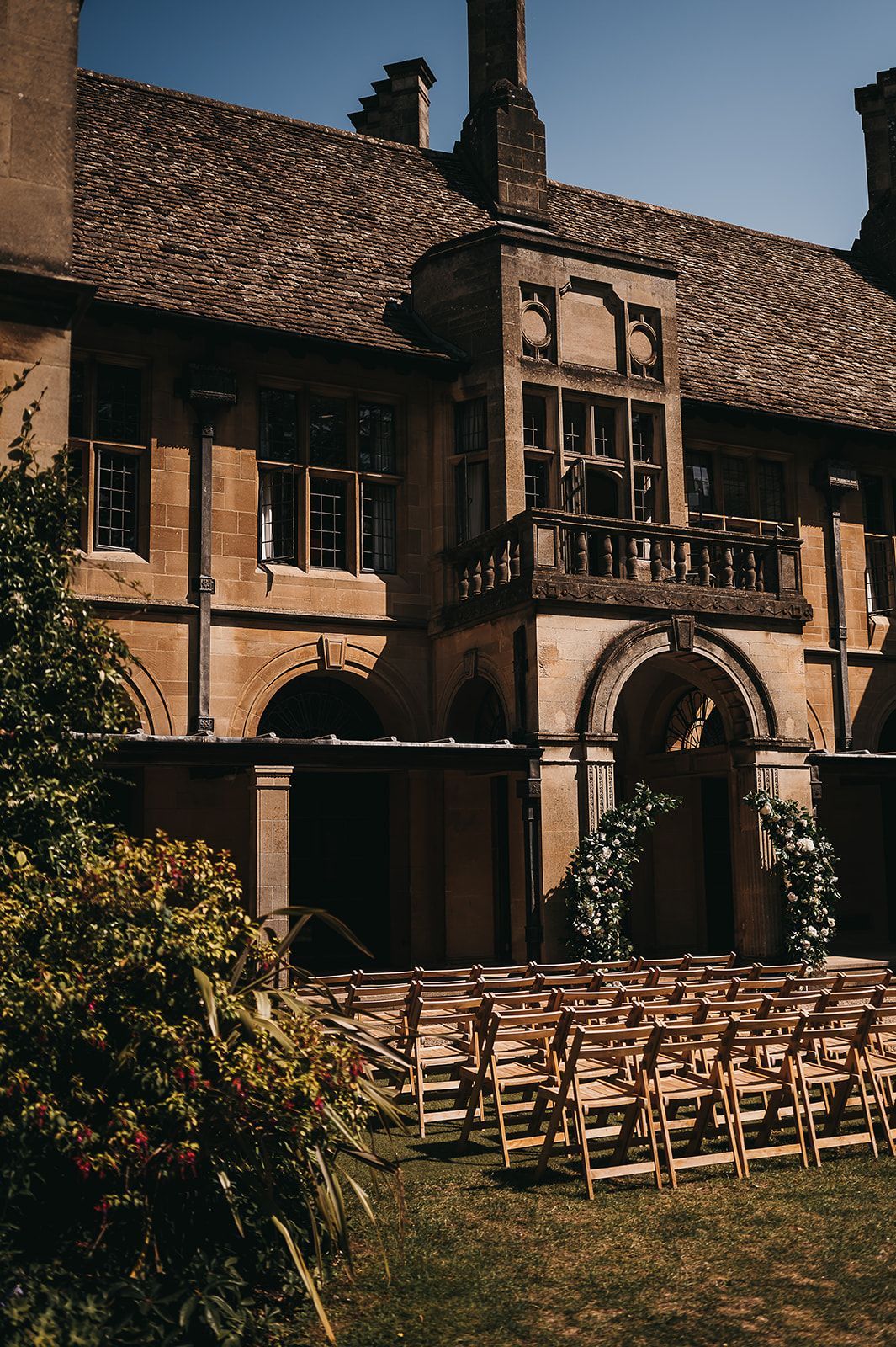 A row of wooden chairs are lined up in front of a large building.