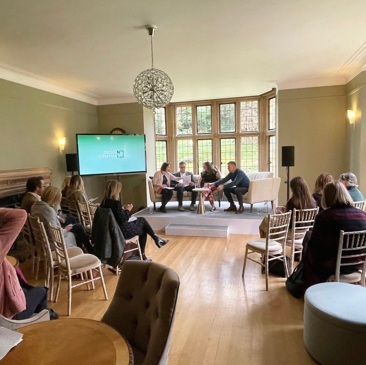 A group of people are sitting around a table in a living room.