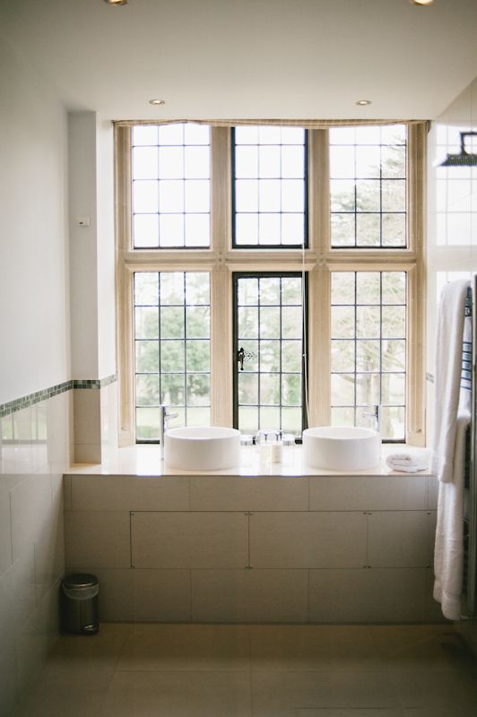 A bathroom with two sinks and a large window.