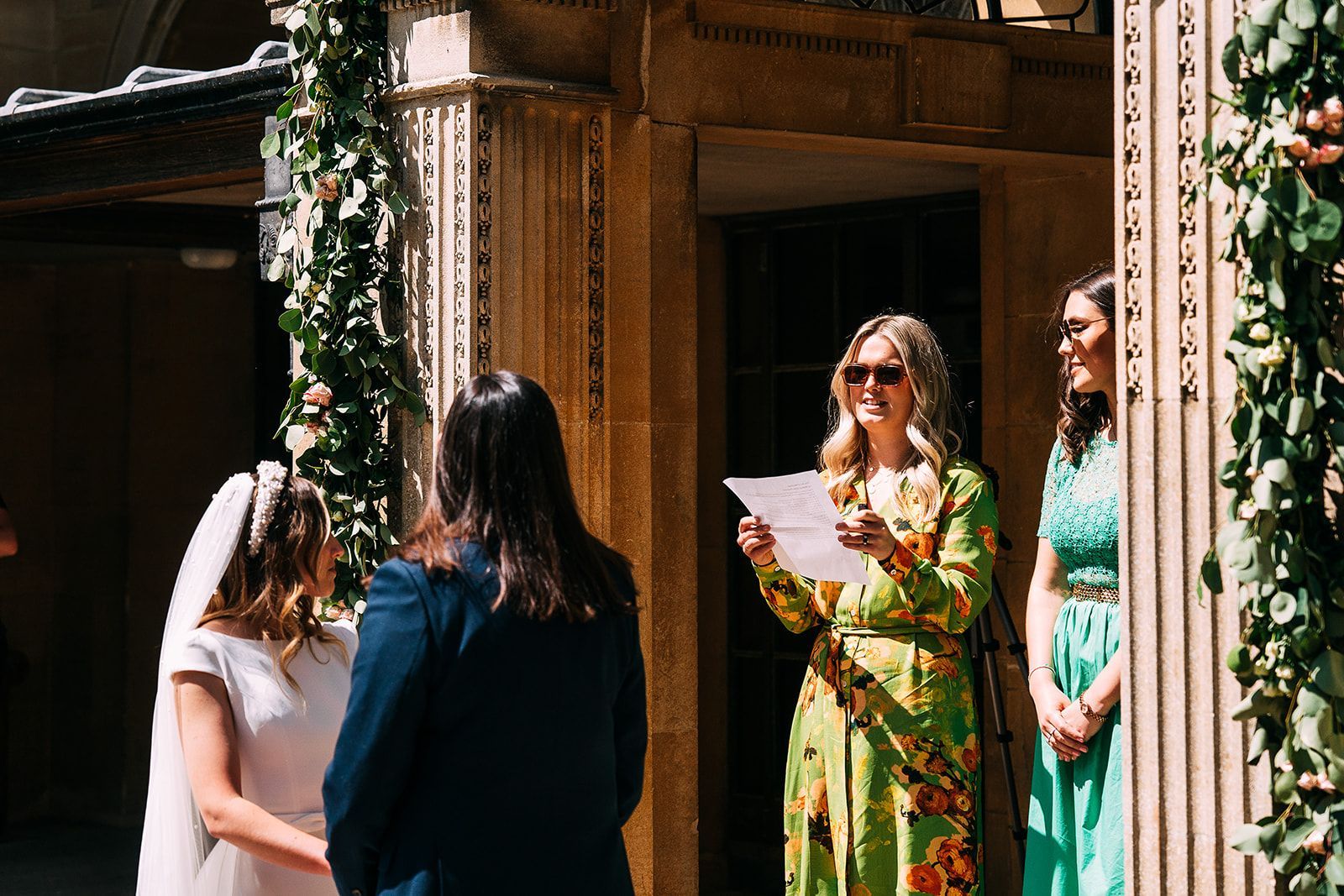 A bride and groom are getting married in front of a building.