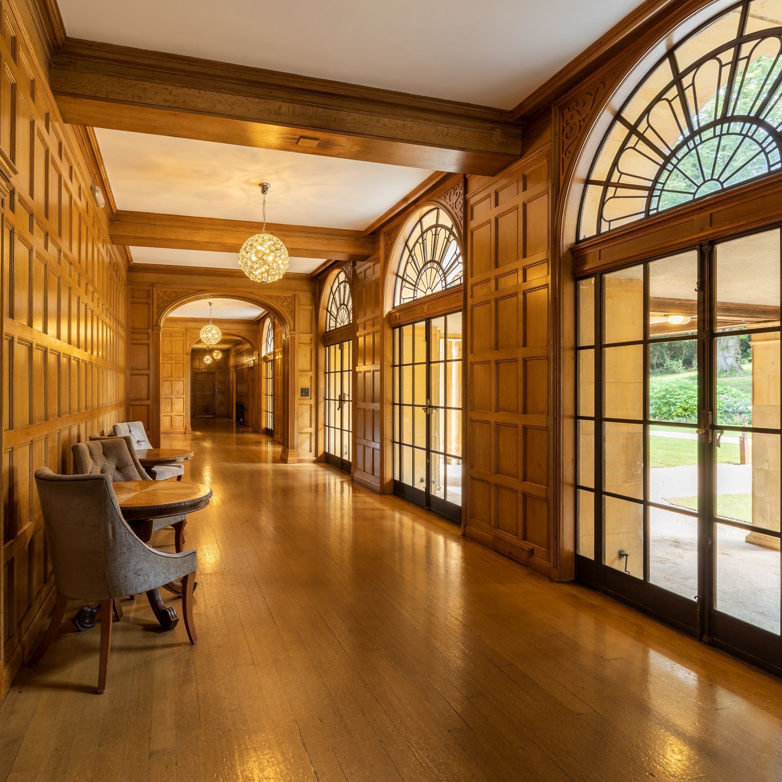 A long hallway with wood paneling and lots of windows