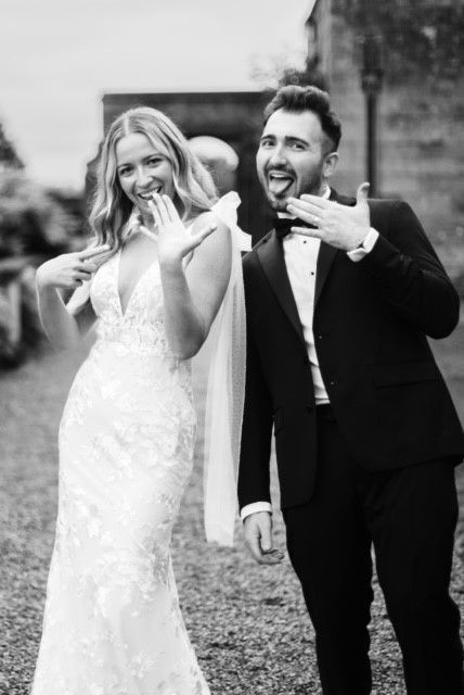 A black and white photo of a bride and groom making funny faces.
