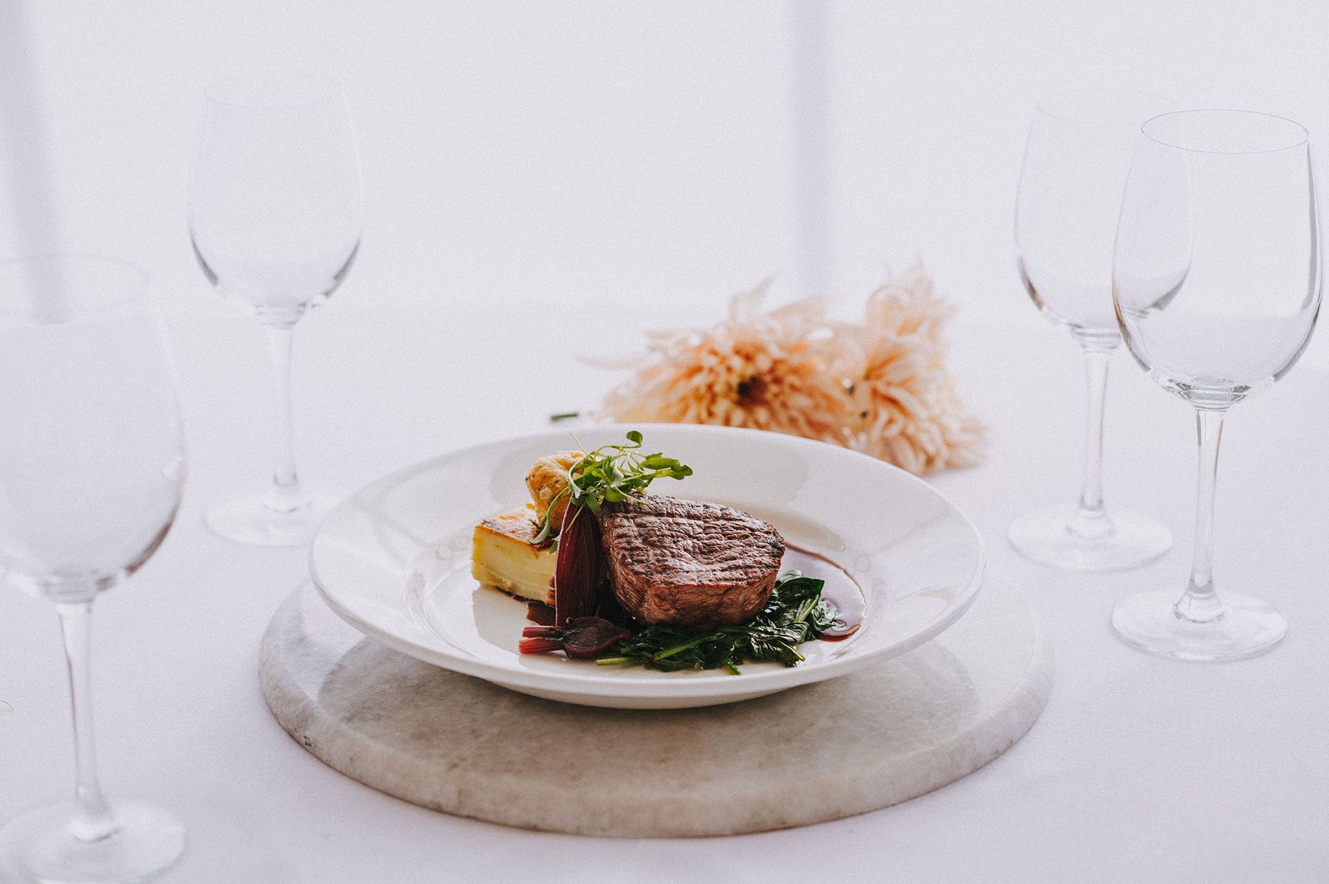 A plate of food and wine glasses on a table.