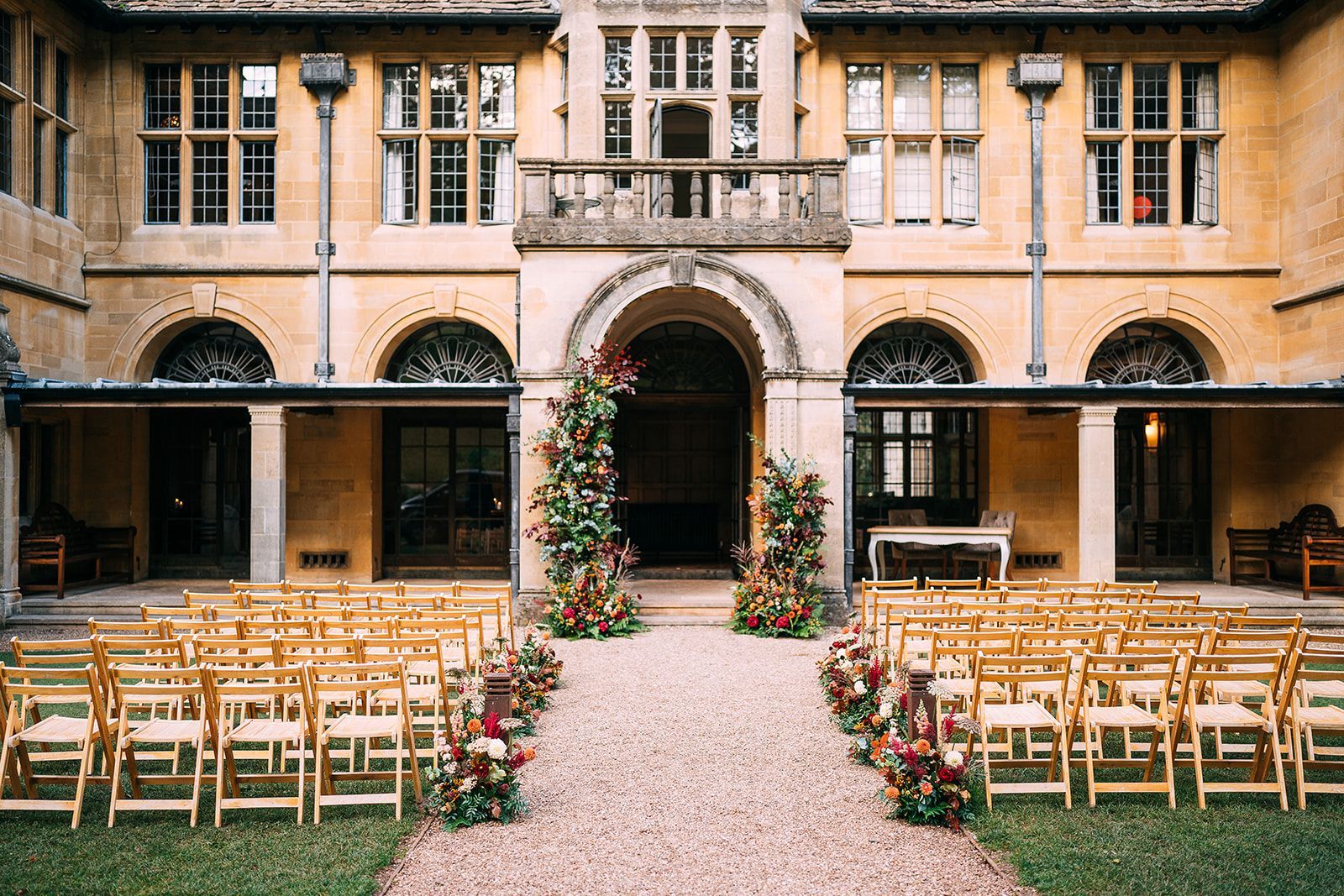 A row of wooden chairs are lined up in front of a large building.