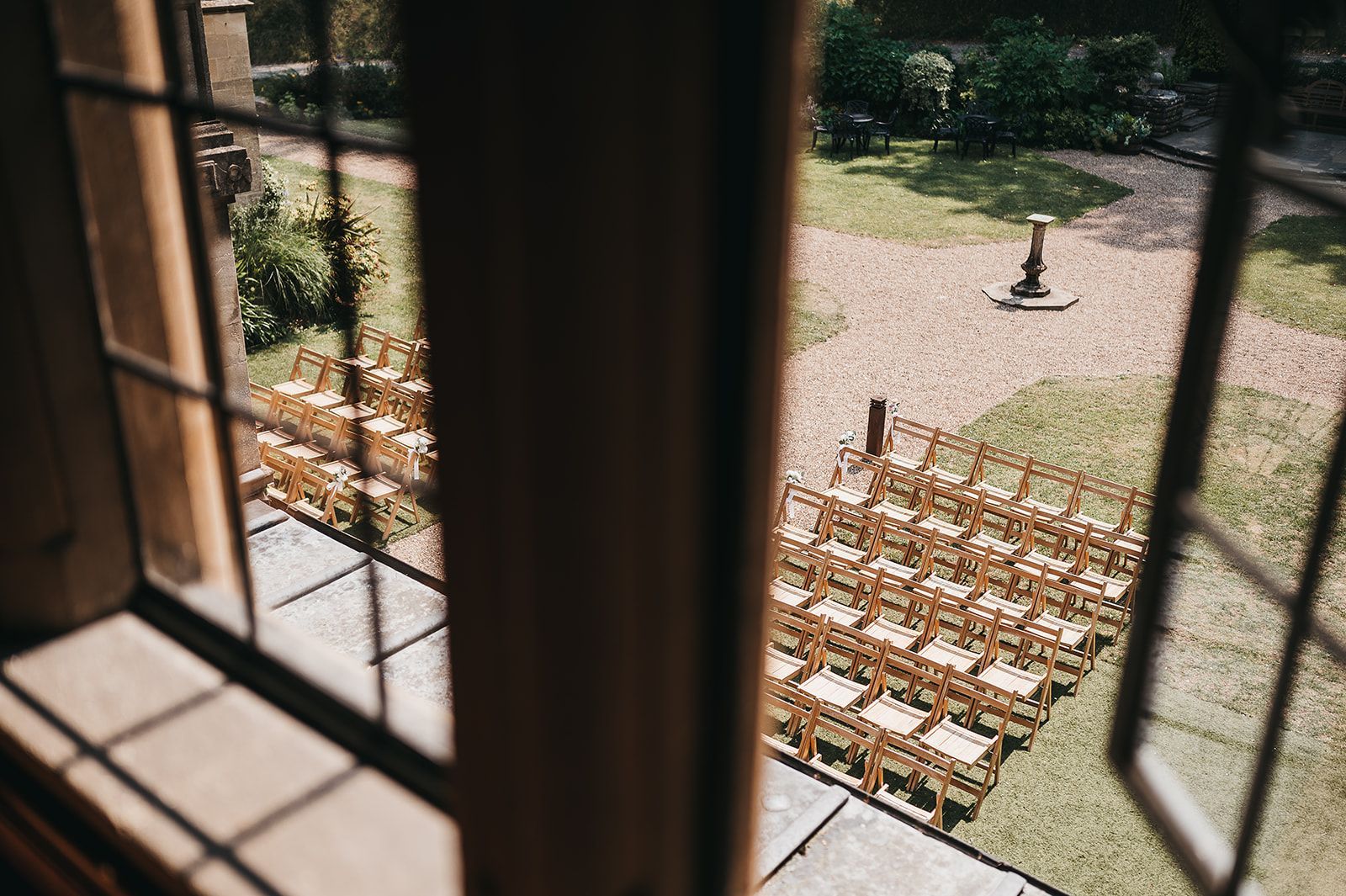 A row of wooden chairs are lined up in a row in front of a window.