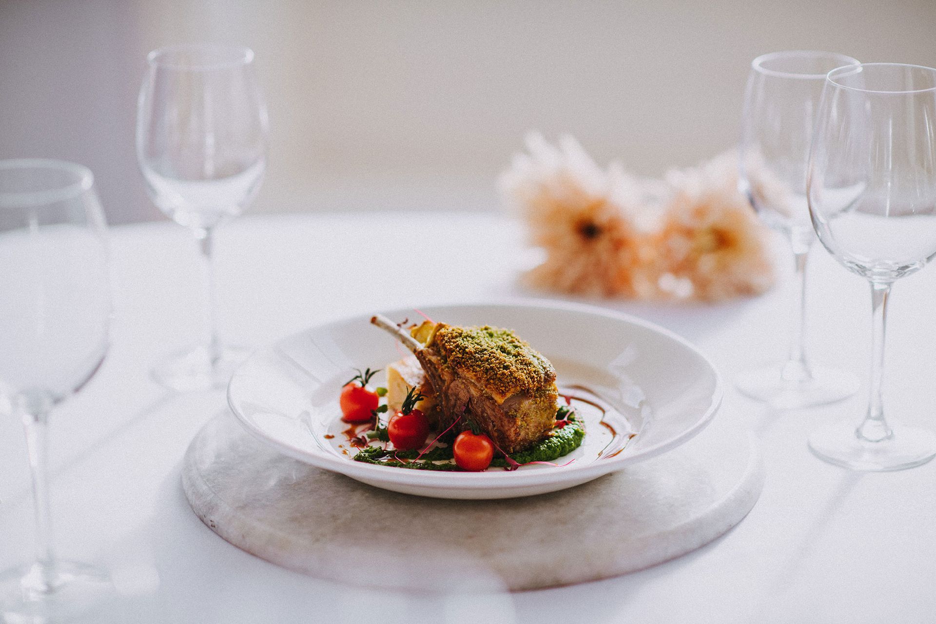 A plate of food and wine glasses on a table.