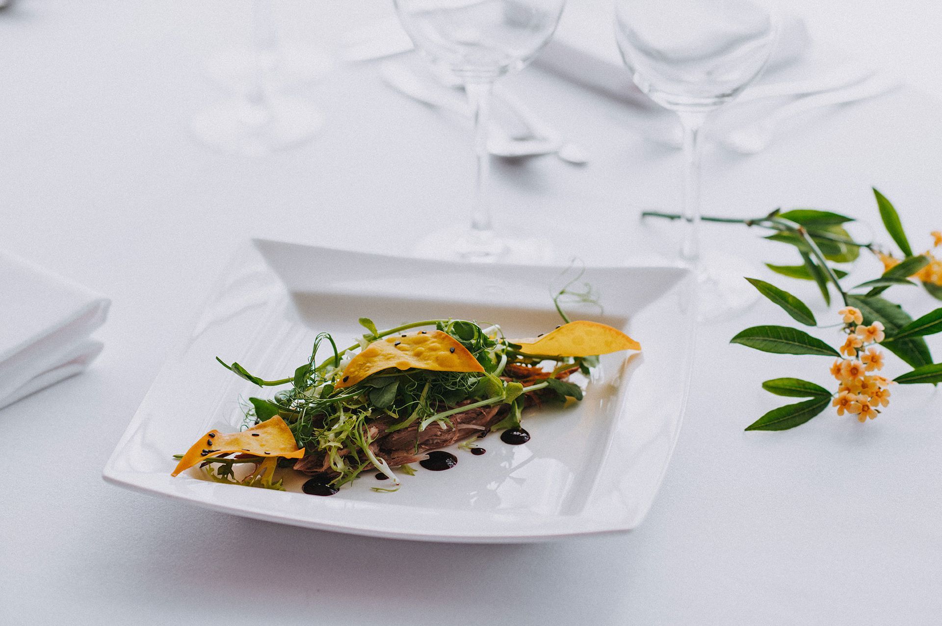 A white plate topped with a salad on a table.