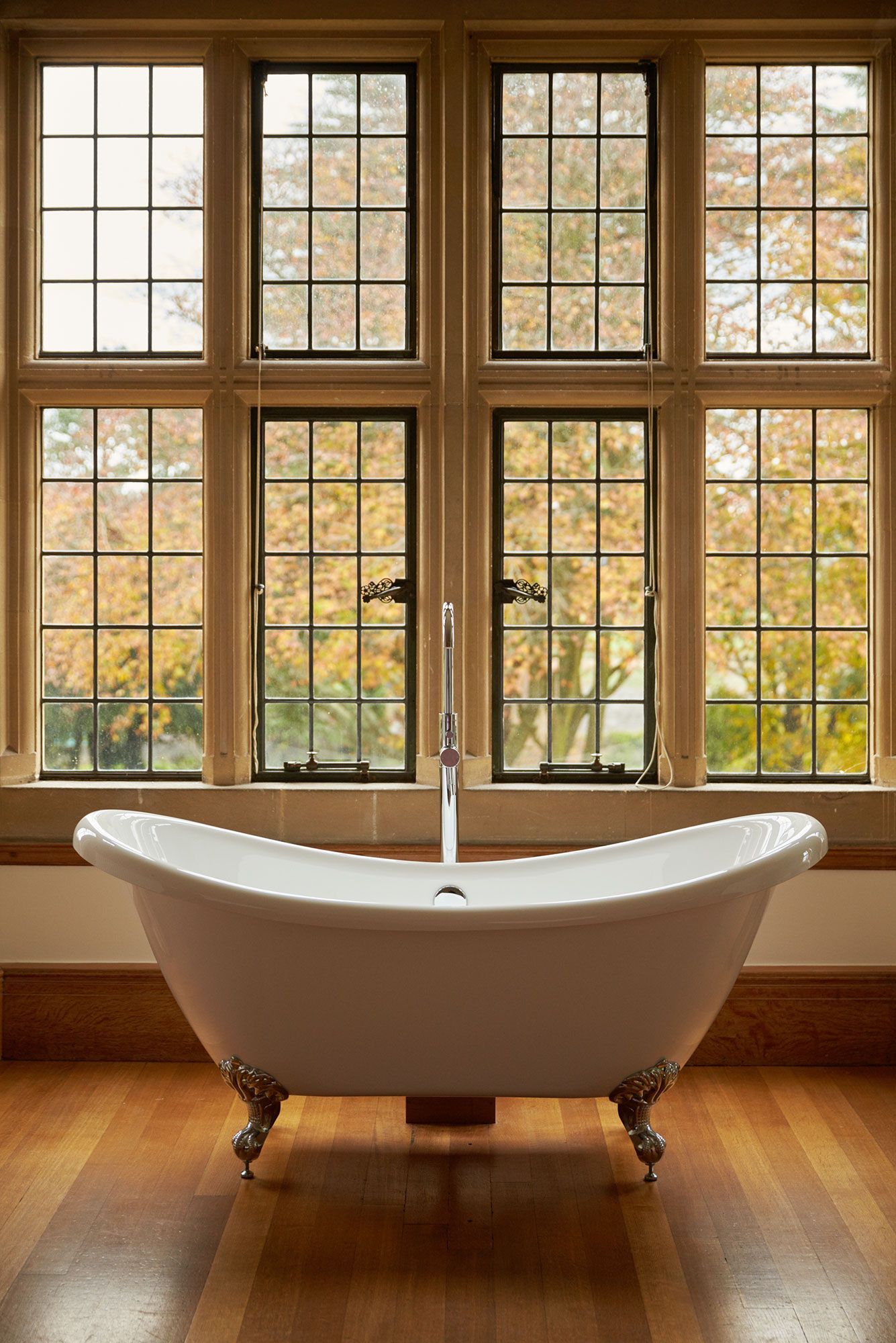 A bathtub is sitting in front of a window in a bathroom.
