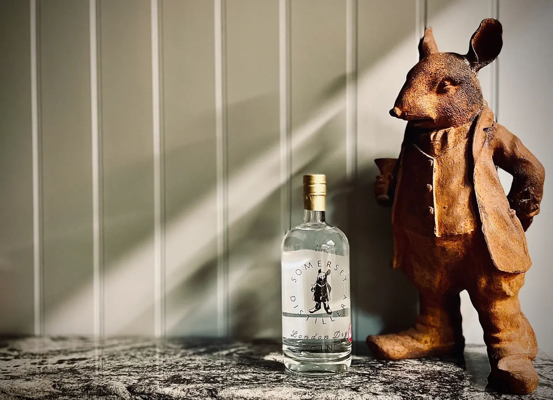 A statue of a bear standing next to a bottle of alcohol
