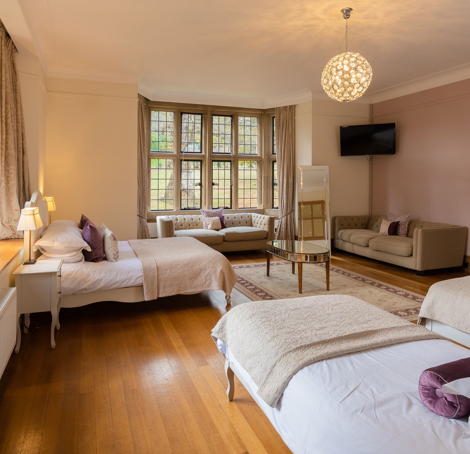 A bedroom with two beds a couch and a television
