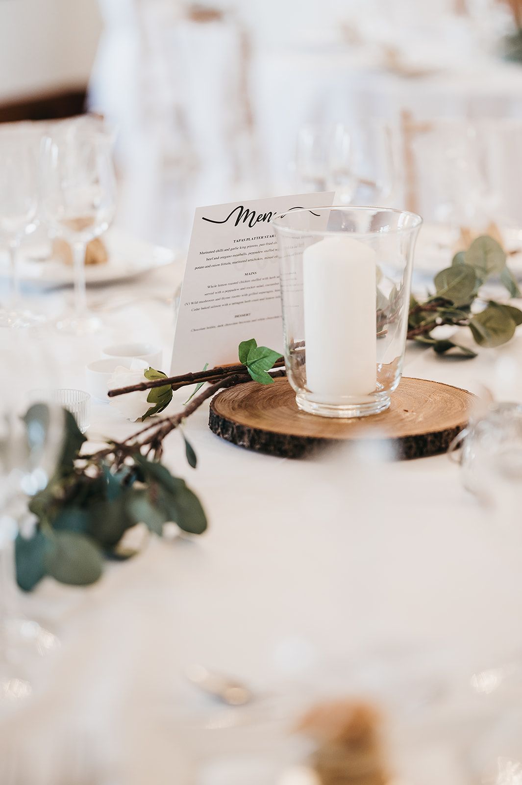 A candle is sitting on top of a wooden slice on a table.