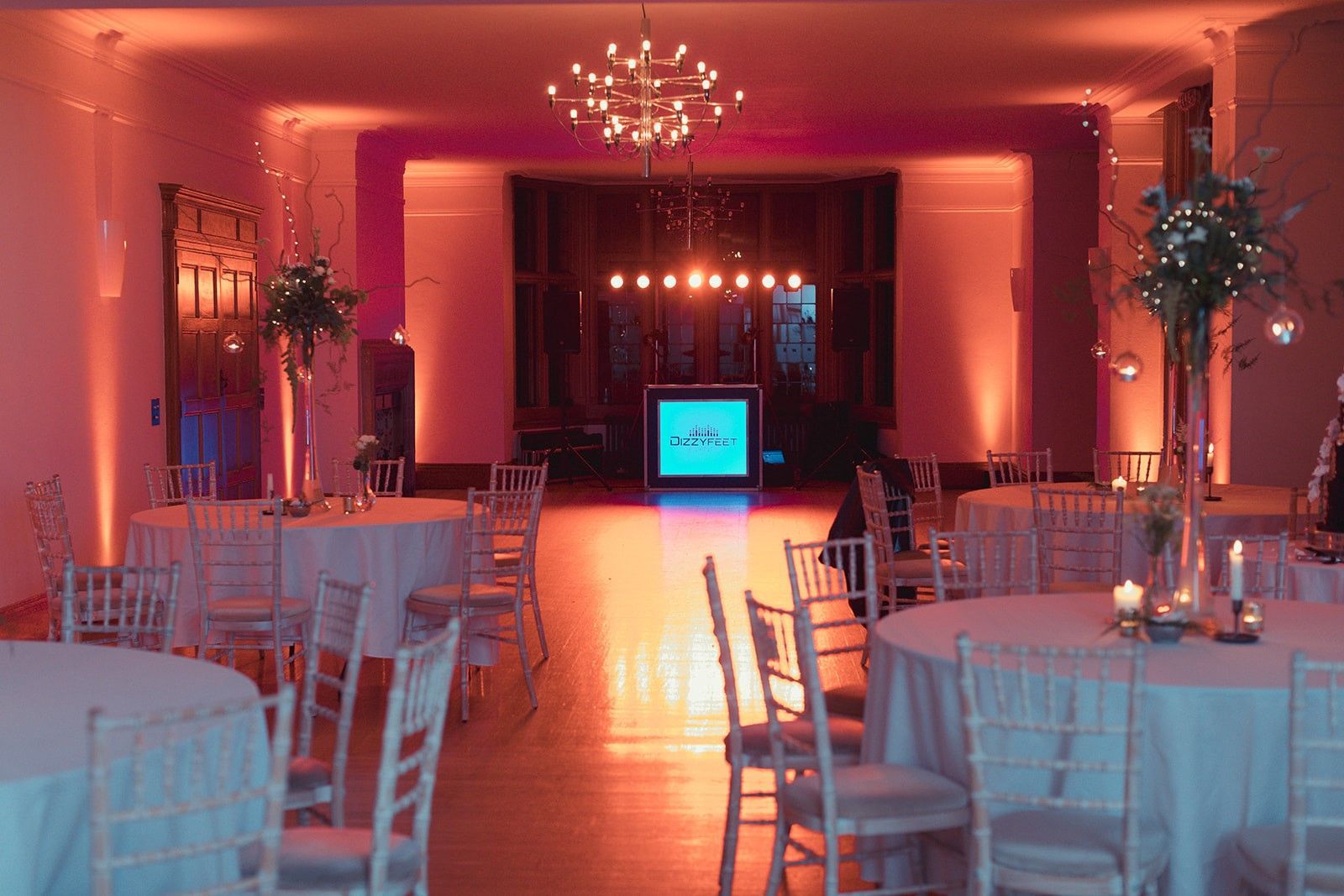A large room with tables and chairs set up for a wedding reception.