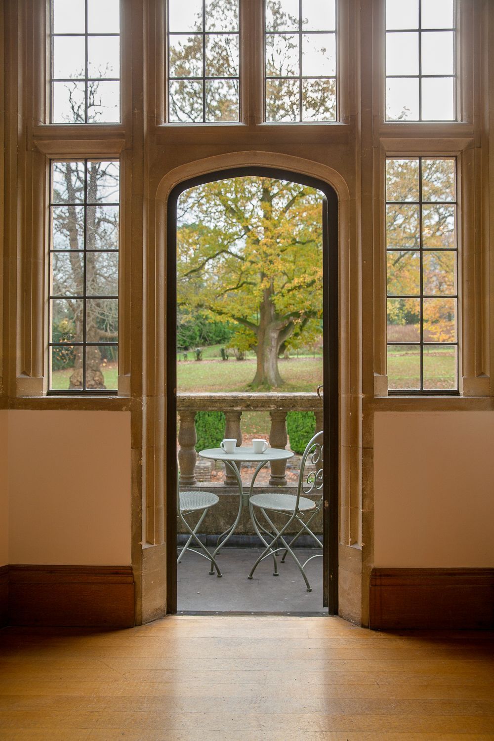A room with a table and chairs in front of a window.