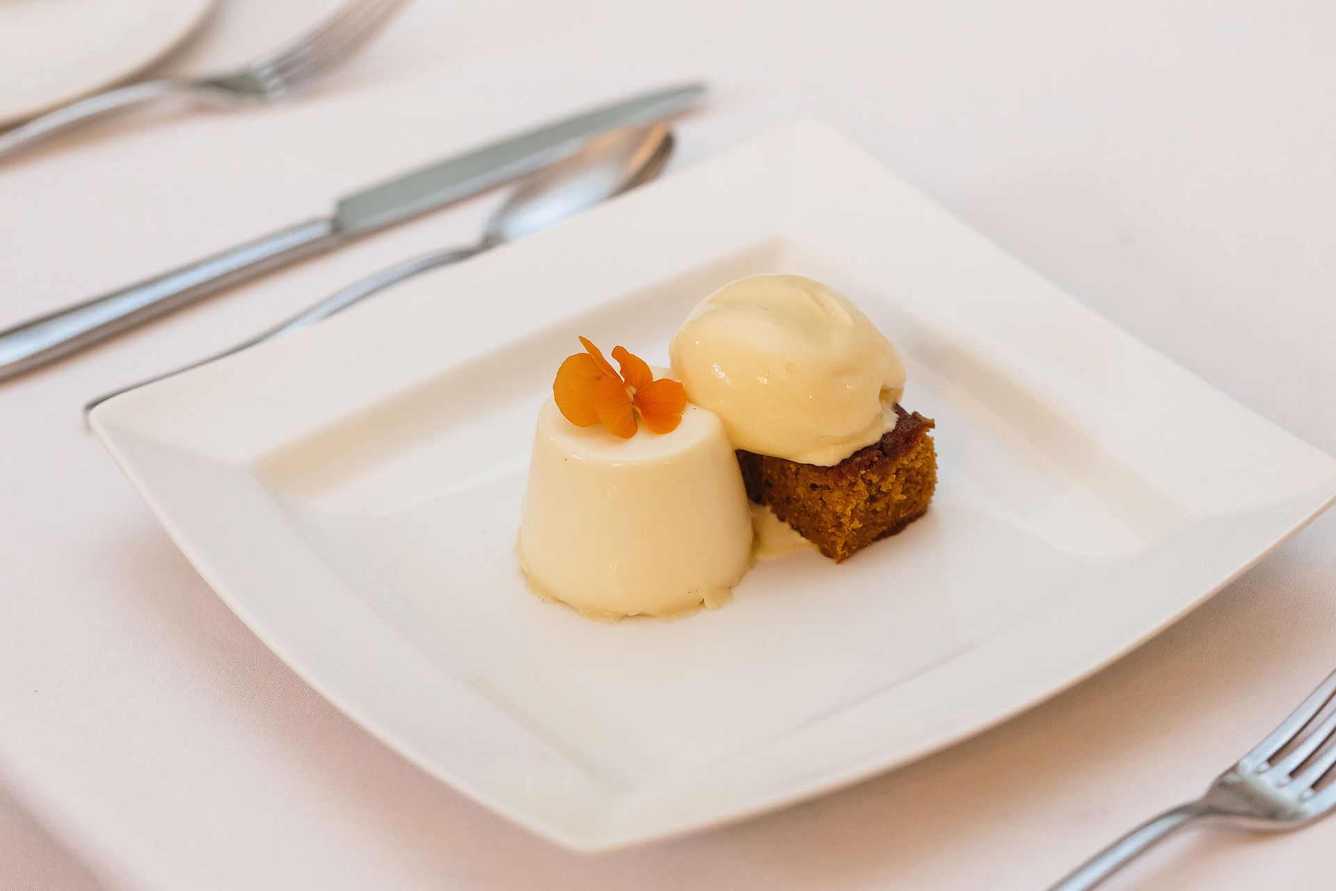 A white plate topped with a dessert and a scoop of ice cream.
